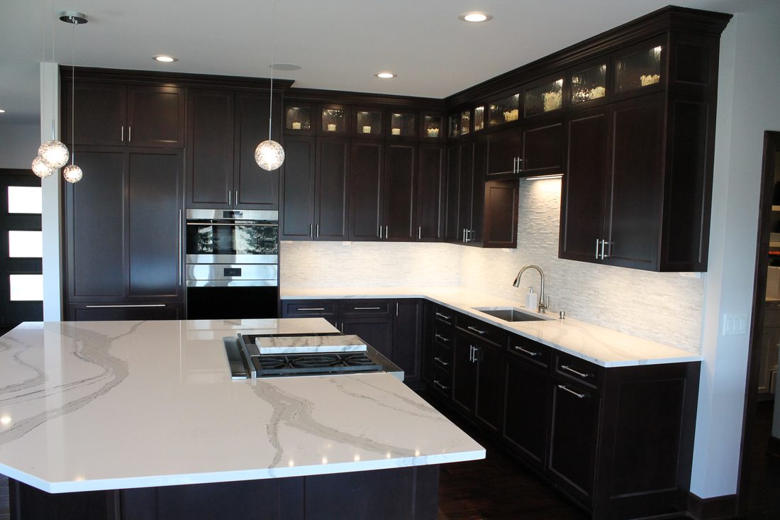 Espresso cabinetry with quartz counters and marble-look backsplash
