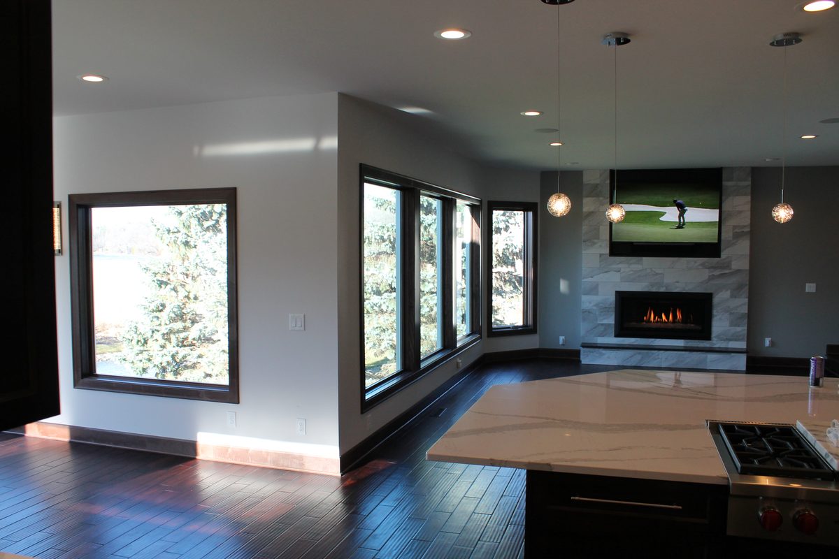 Open main level with linear fireplace and a wall of windows