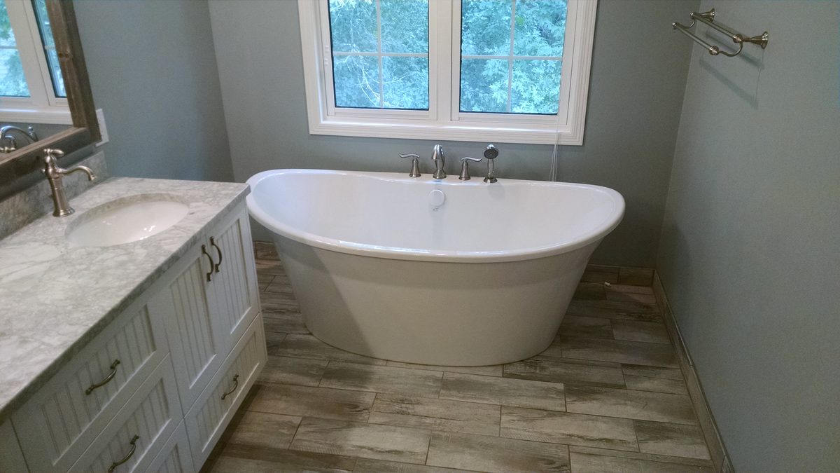 Bathroom remodel with a freestanding tub and tile floor in Savage